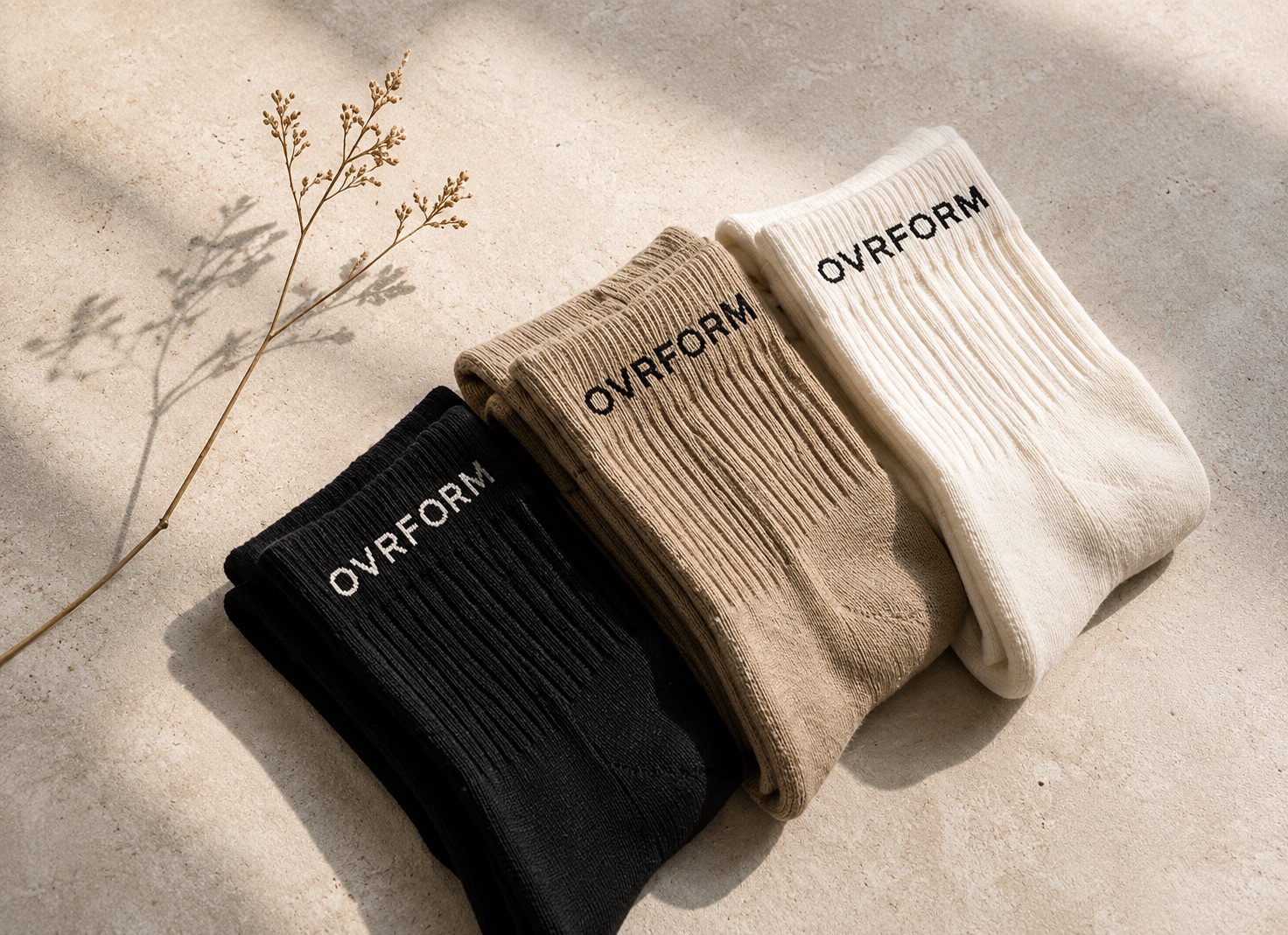 OVRFORM grip socks in cream, oat and black on a warm studio surface